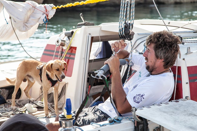 A man and a dog sitting on a boat